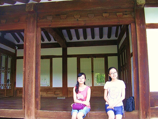 Traditional Korean House with two people sitting in it 